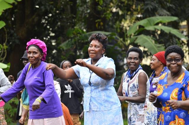 Women take part in a guided exercise session outdoors.