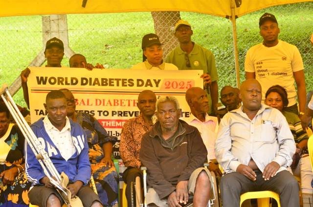 Men seated in a row at an RDAF event with crutches resting beside them.