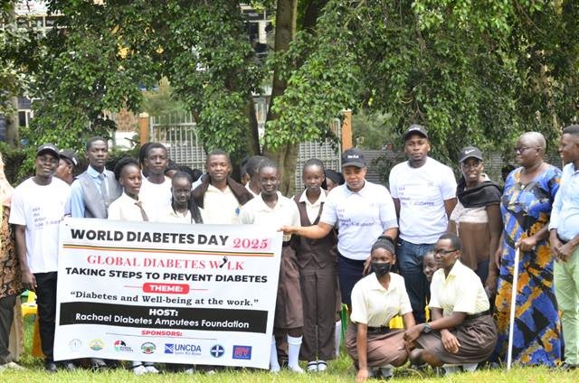 Schoolchildren and community members stand together behind an RDAF World Diabetes Day banner.